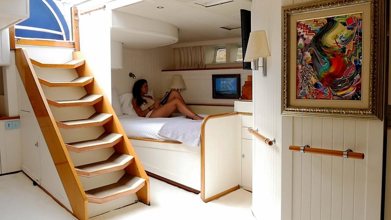 a person sitting on a bed aboard INGENIOUS Yacht for Sale