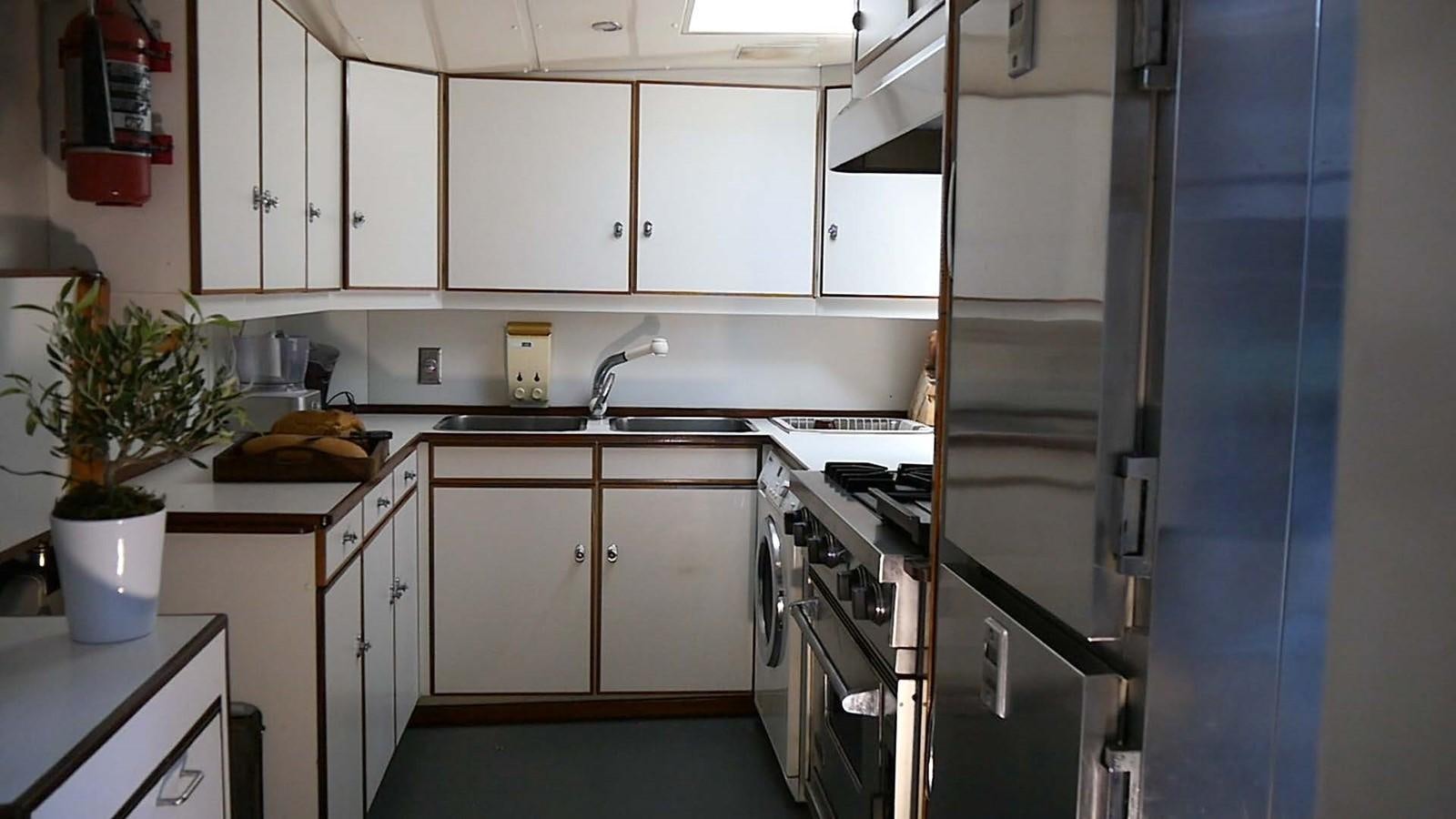 a kitchen with white cabinets aboard INGENIOUS Yacht for Sale