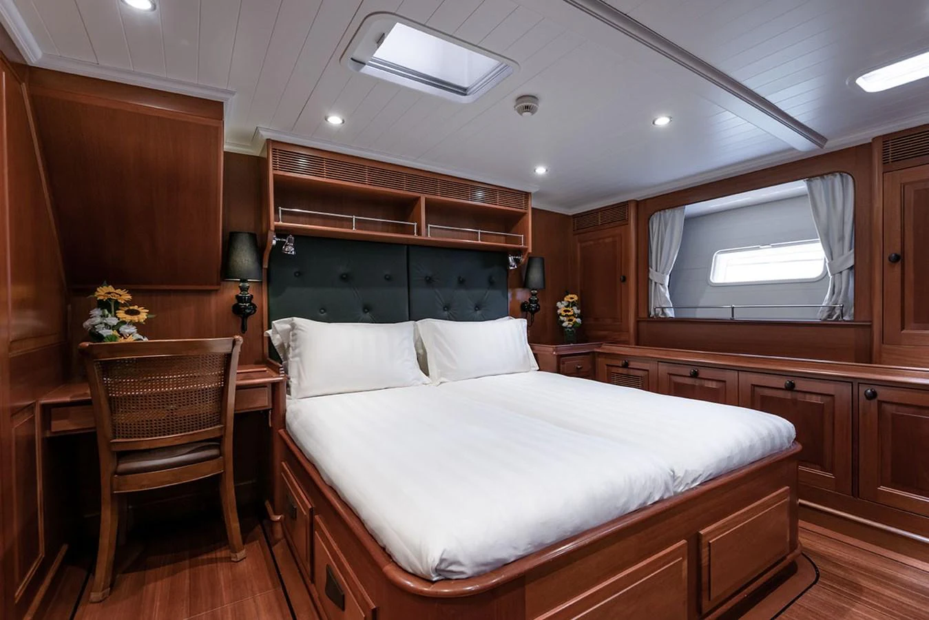 a bedroom with a bed and a chair aboard PATH Yacht for Sale