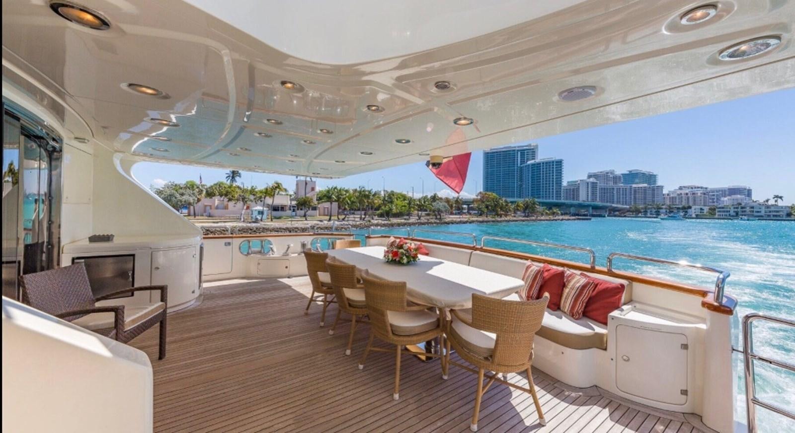 a room with a table chairs and a view of a city aboard AVA Yacht for Sale