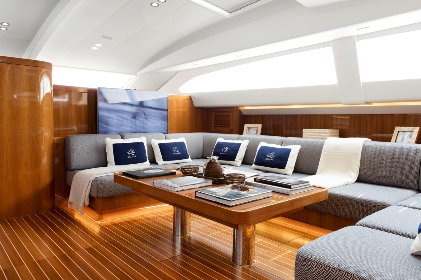 a room with a couch and a table with laptops on it aboard SOLLEONE Yacht for Sale