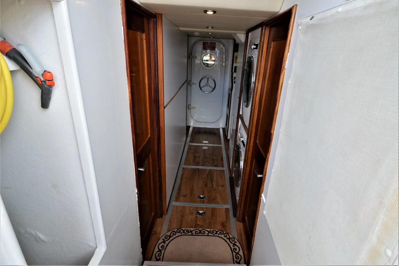 a hallway with a door and a clock on the wall aboard MISS STEPHANIE Yacht for Sale