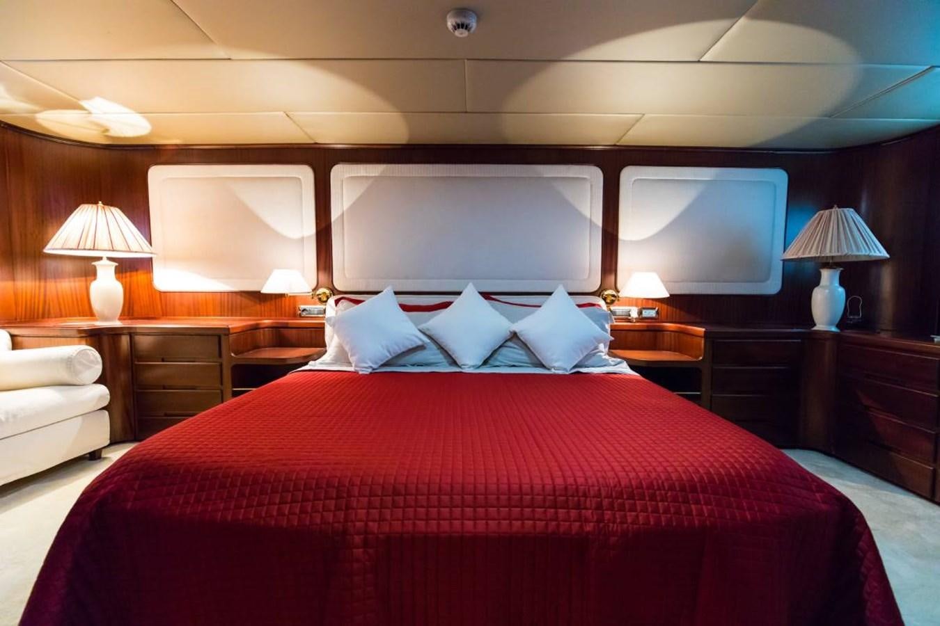 a bed with a red comforter aboard INDIA Yacht for Sale