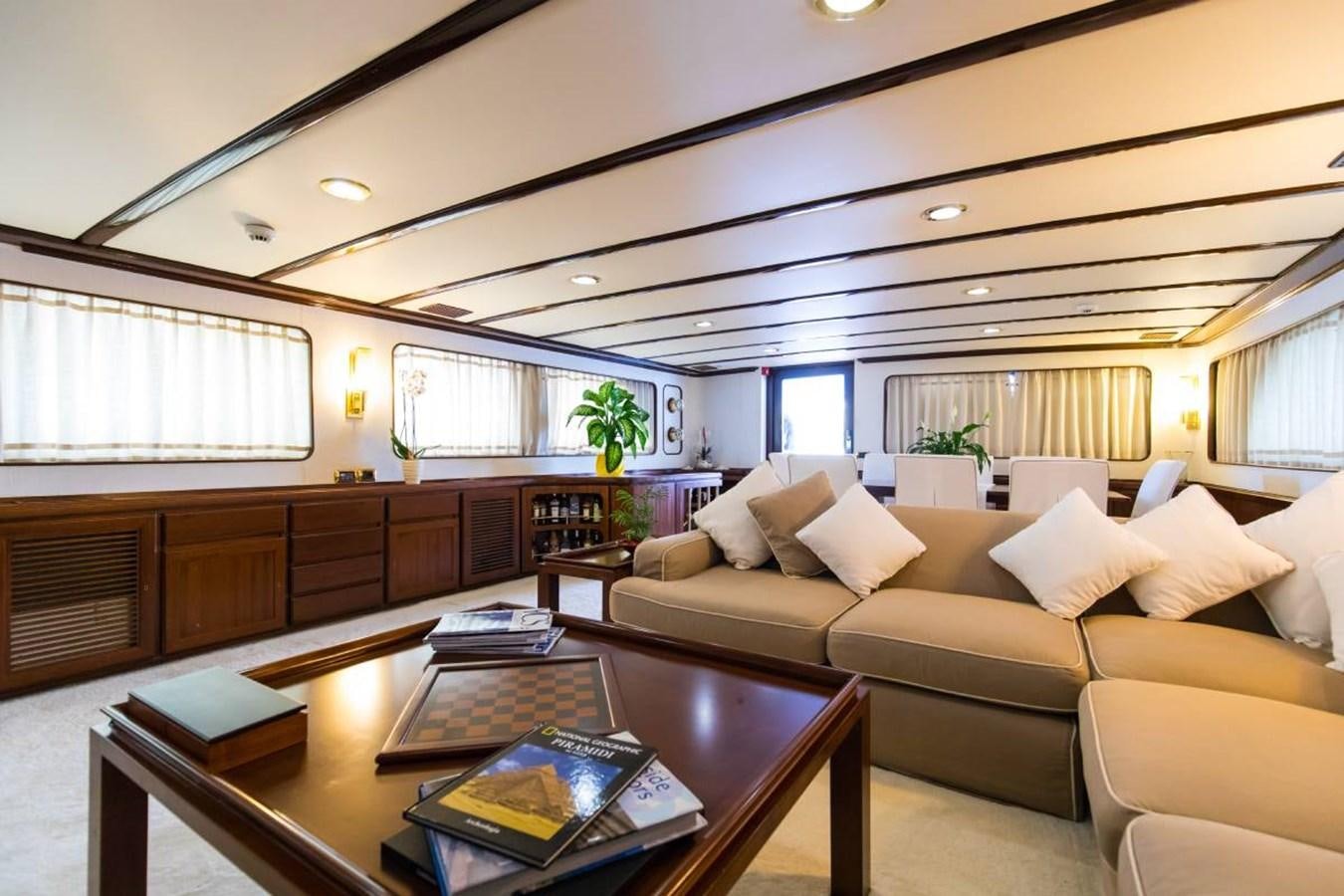 a living room with a large sofa aboard INDIA Yacht for Sale