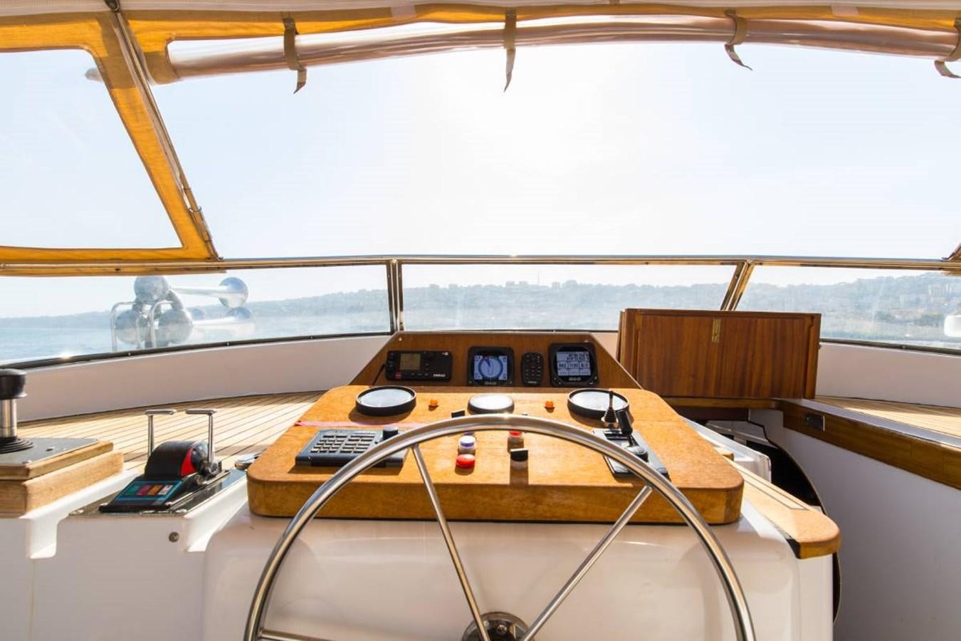 a wooden table with a radio and a radio on it aboard INDIA Yacht for Sale