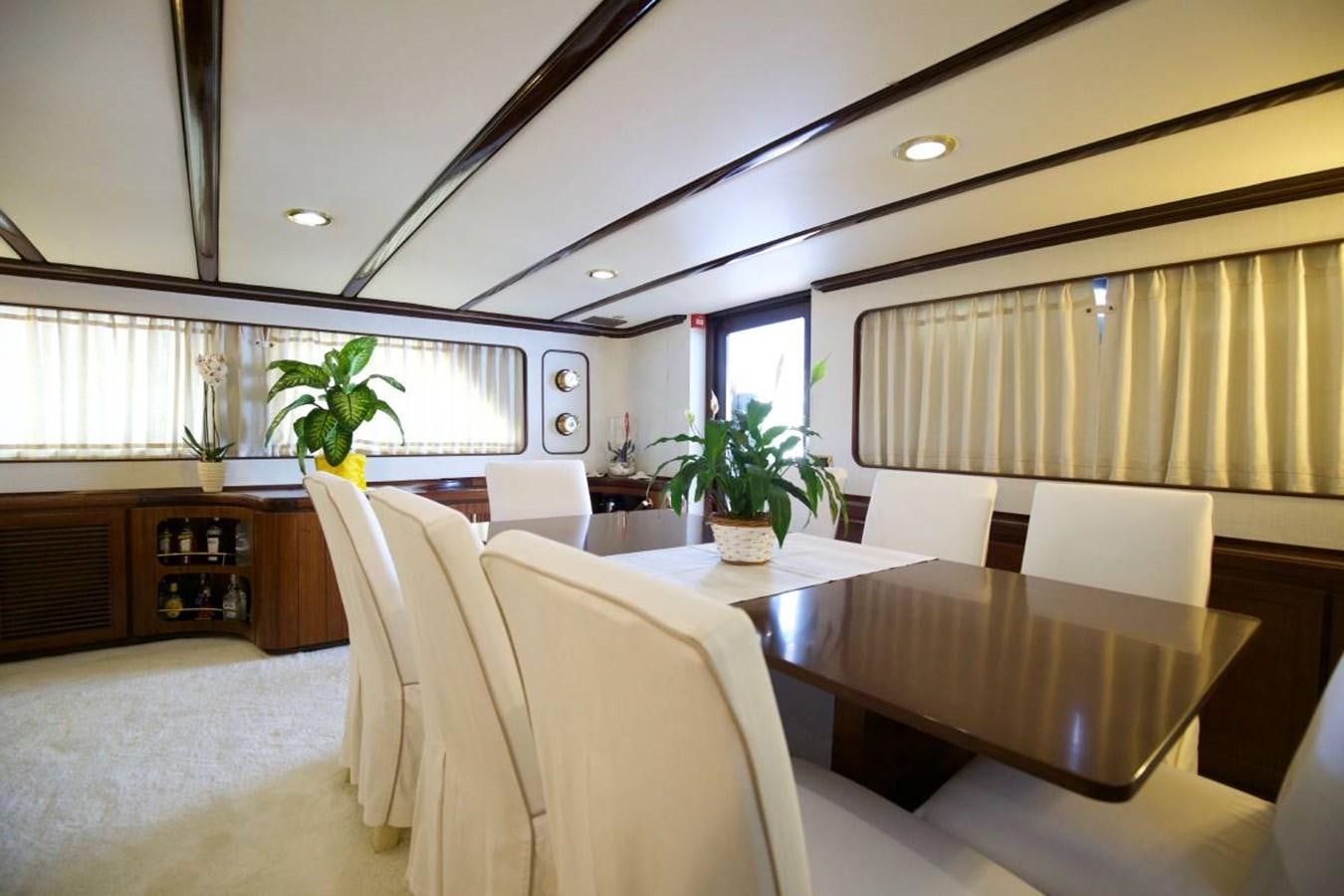 a room with a table and chairs aboard INDIA Yacht for Sale