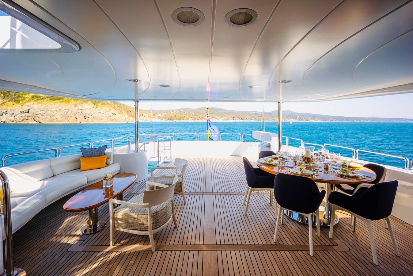 a table set for a meal on a deck overlooking the ocean aboard SERENO Yacht for Sale