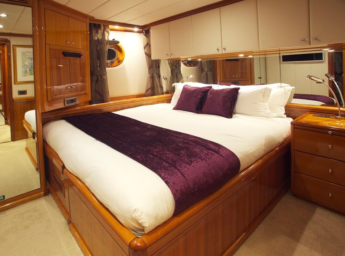 a bed with a white sheet aboard REE Yacht for Charter