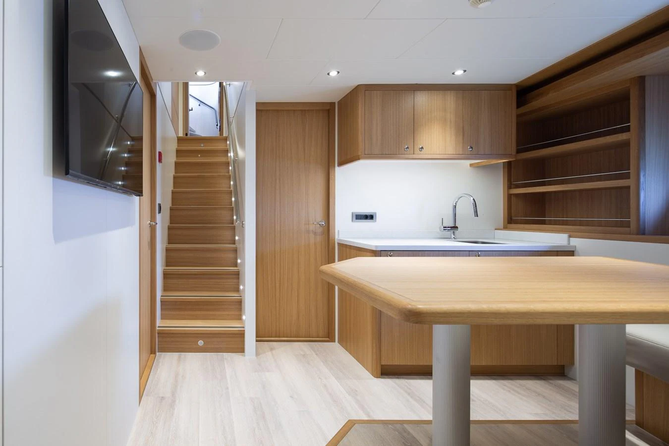 a kitchen with a table and a sink aboard MOONEN 110 MUSTIQUE Yacht for Sale