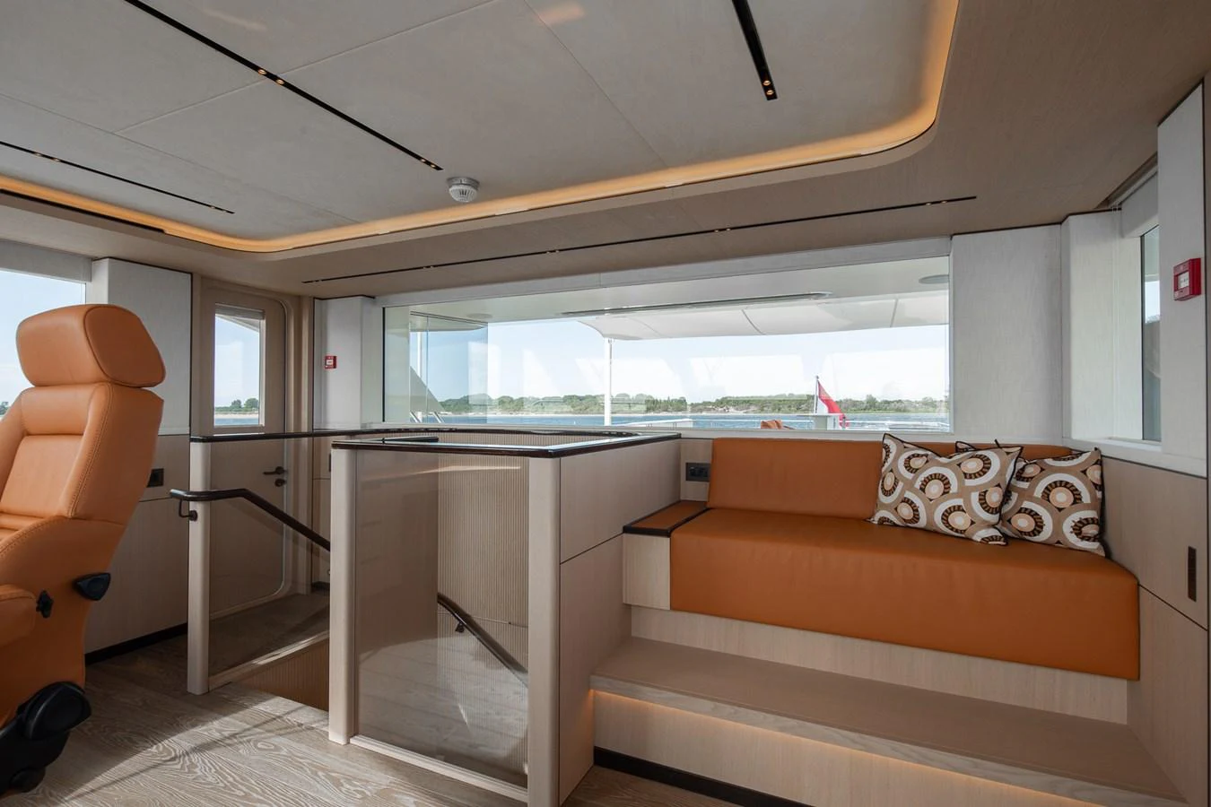 a living room with a couch and a table aboard MOONEN 110 MUSTIQUE Yacht for Sale