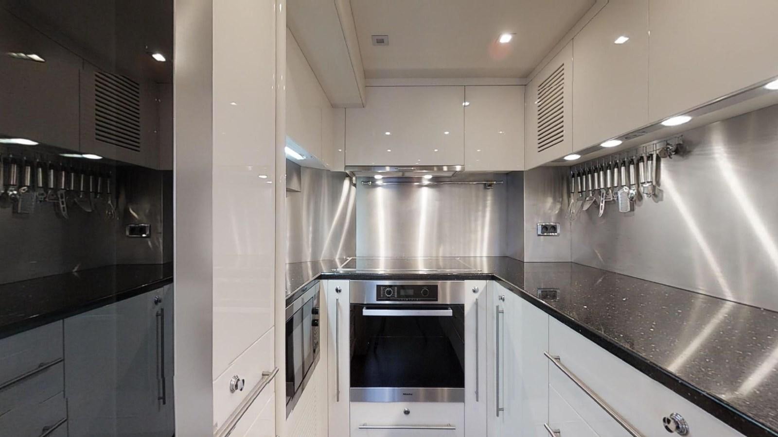 a kitchen with stainless steel appliances aboard WHITE PEARL I Yacht for Sale