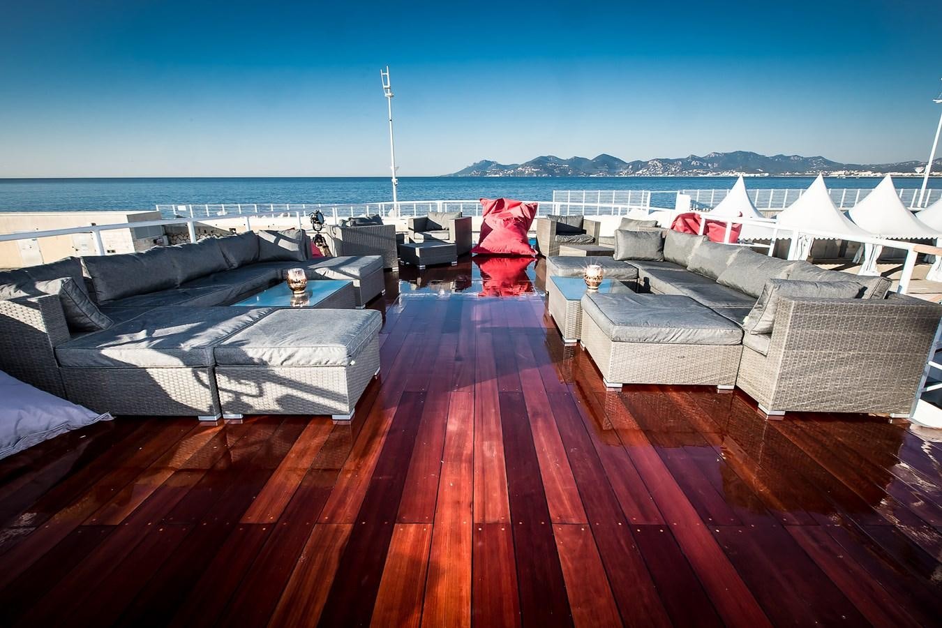 a deck with a deck and a red and white deck with white tents and a red tree on aboard ALTER EGO Yacht for Sale