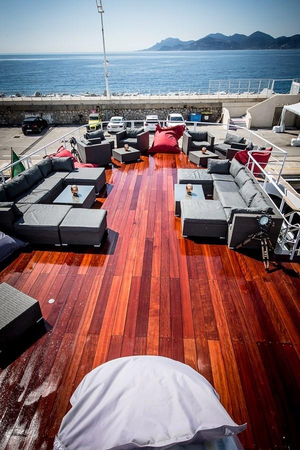 a large orange deck with a beach and a large body of water aboard ALTER EGO Yacht for Sale