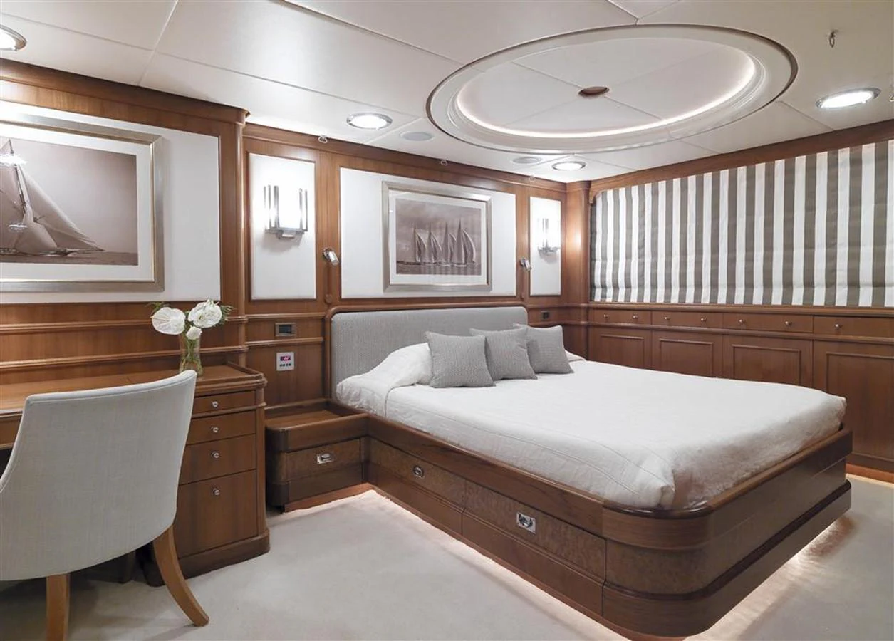 a bedroom with a bed and a chair aboard SPADA Yacht for Sale