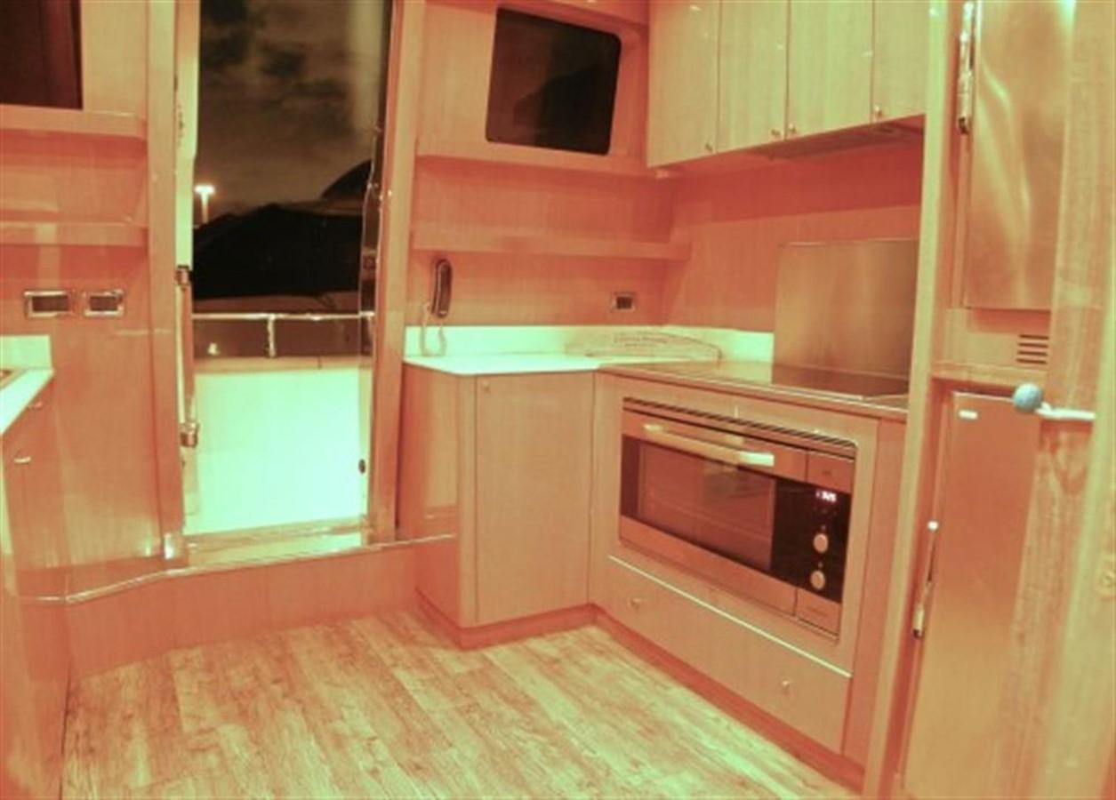 a kitchen with wooden cabinets aboard TECNOMAR 34 NADARA Yacht for Sale
