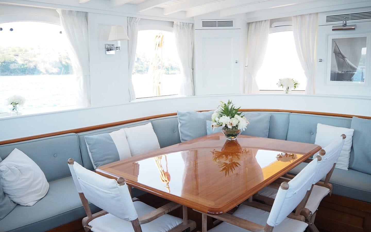 a table with chairs and a couch aboard IDUNA Yacht for Sale