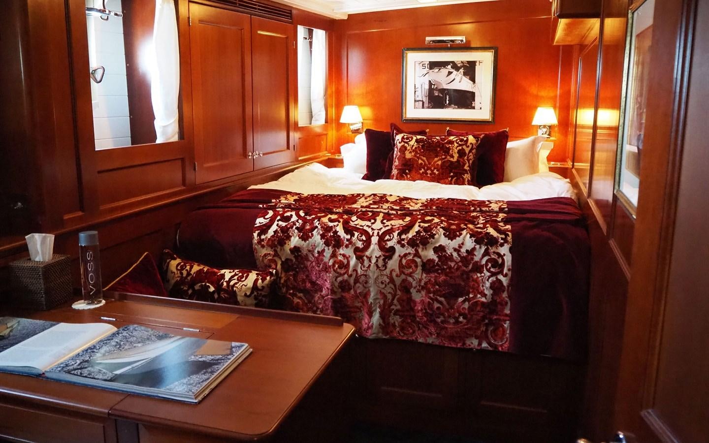 a bed with a red and white patterned blanket aboard IDUNA Yacht for Sale