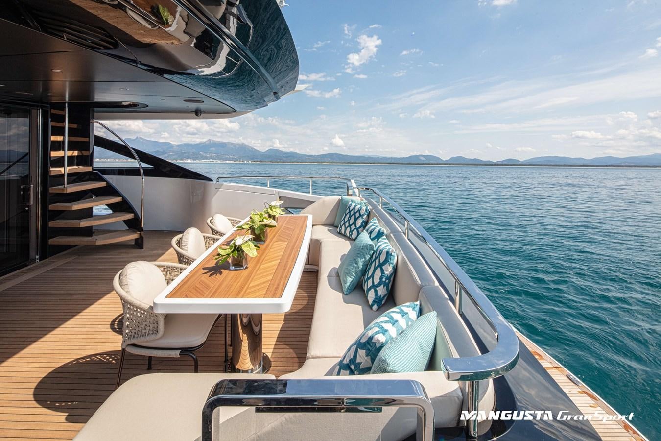 a deck with a table and chairs on it aboard C2 Yacht for Charter