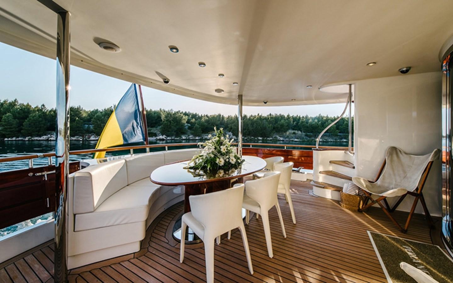 a table and chairs on a deck aboard DREAM Yacht for Sale