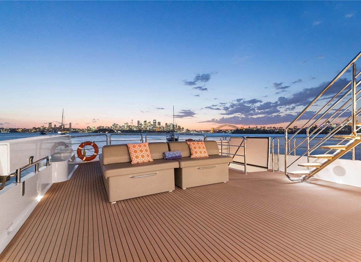a couch on a deck overlooking a body of water aboard CORROBOREE Yacht for Sale