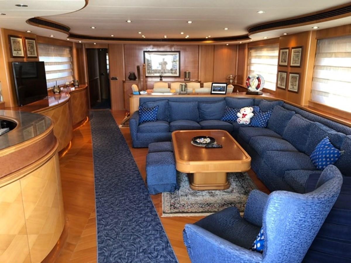 a living room with a blue couch aboard ENERGY Yacht for Sale