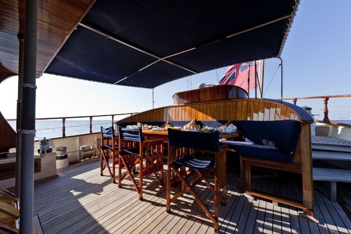 a deck with chairs and tables on it aboard TIGERLILY OF CORNWALL Yacht for Sale