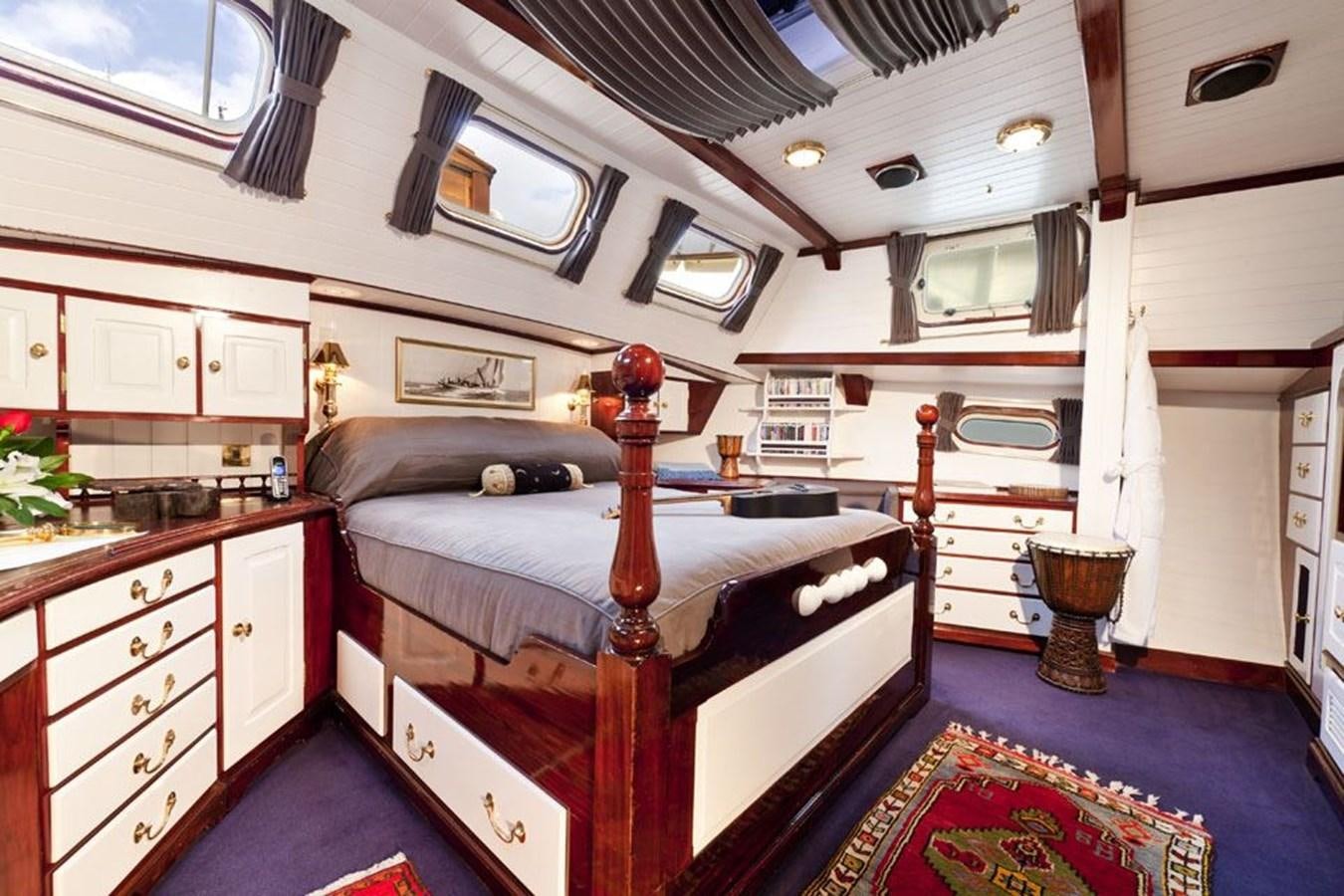 a bedroom with a bed and a desk aboard TIGERLILY OF CORNWALL Yacht for Sale