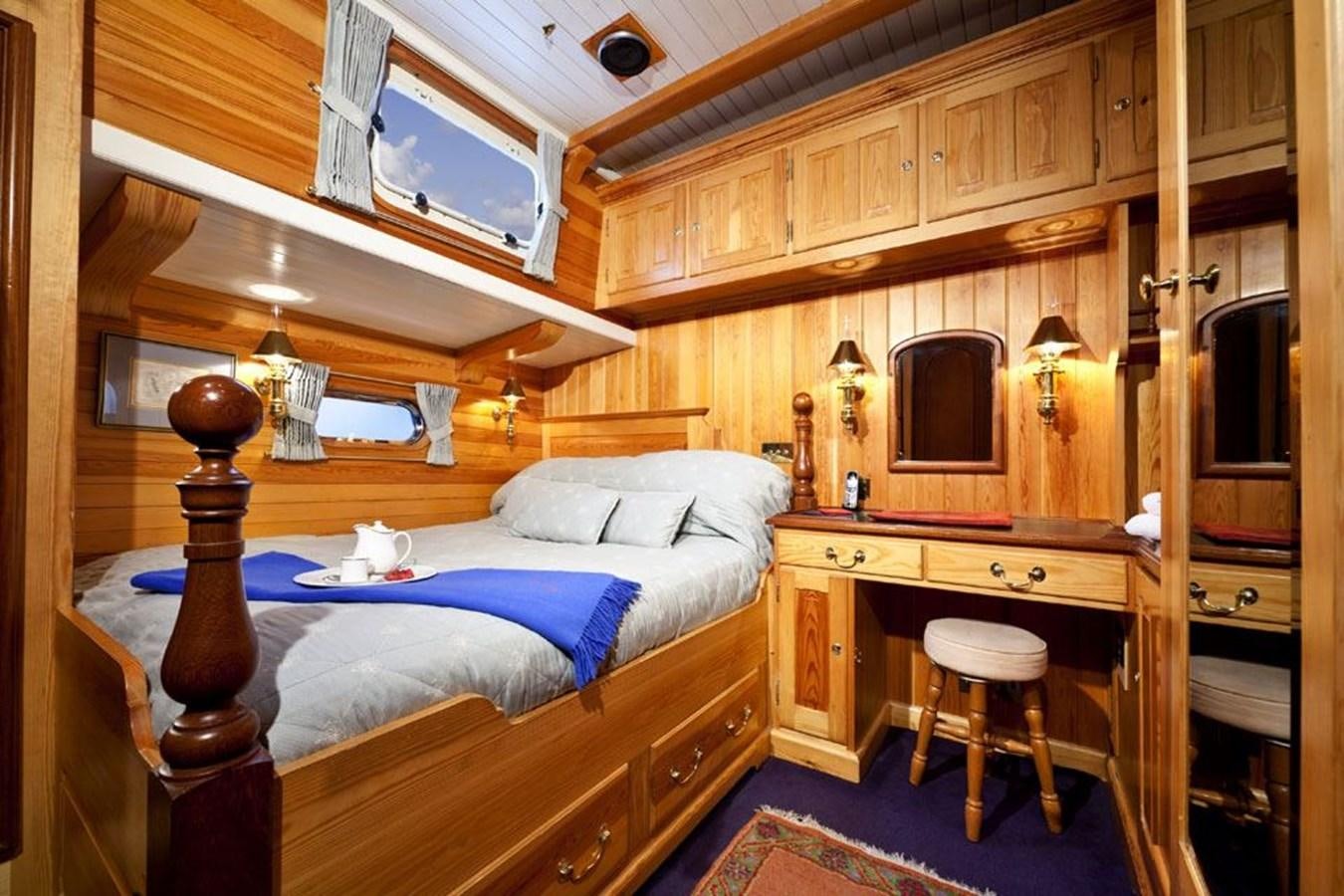 a bedroom with a bed and a desk aboard TIGERLILY OF CORNWALL Yacht for Sale