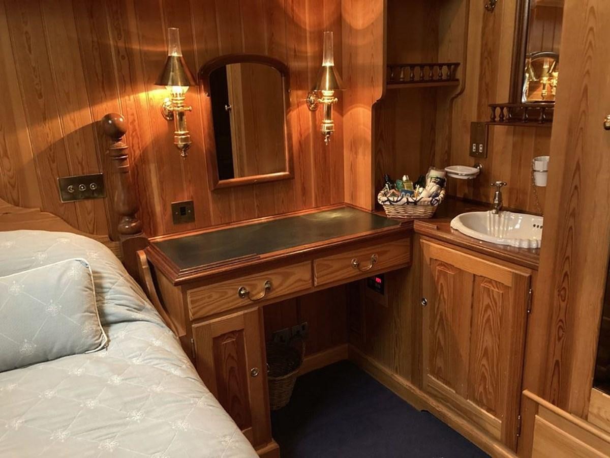 a bedroom with a bed and a mirror aboard TIGERLILY OF CORNWALL Yacht for Sale