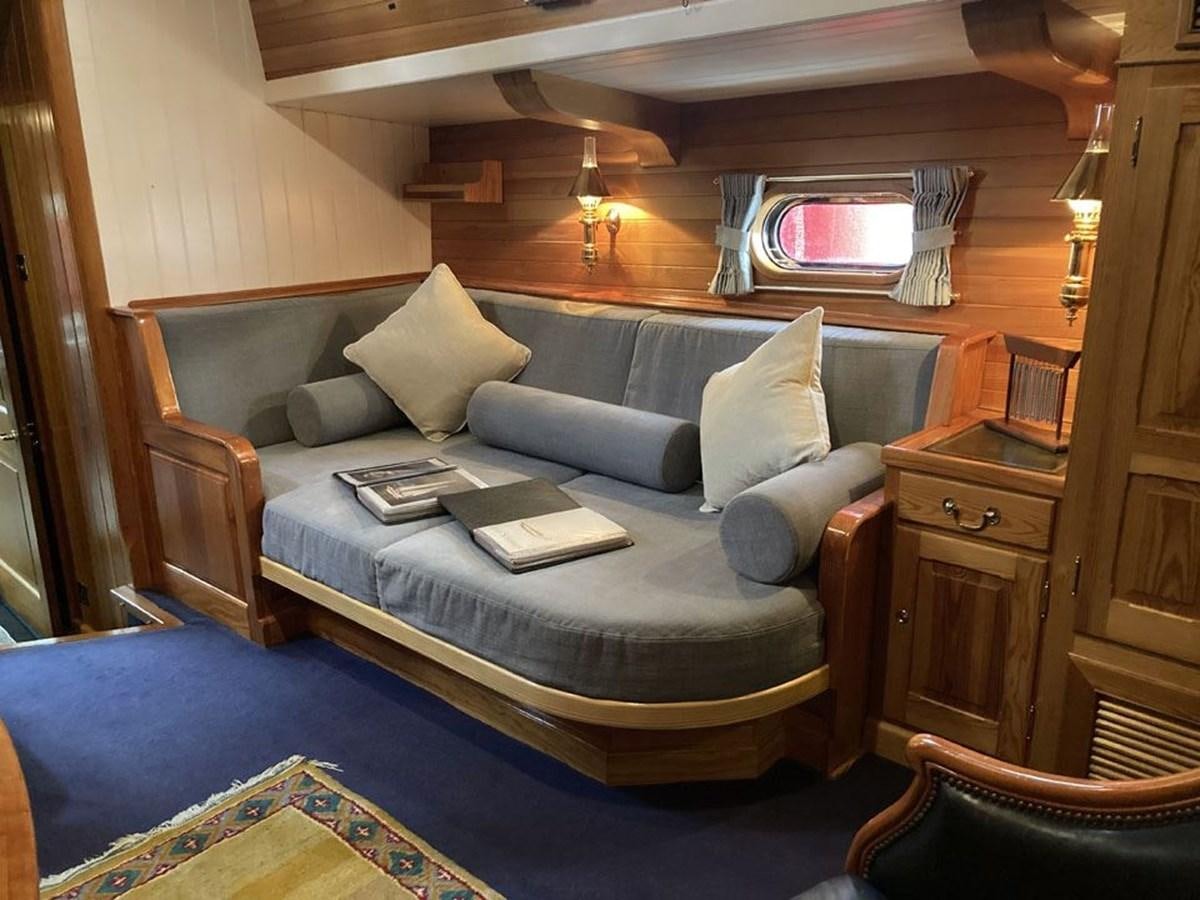 a bed with a blue couch aboard TIGERLILY OF CORNWALL Yacht for Sale