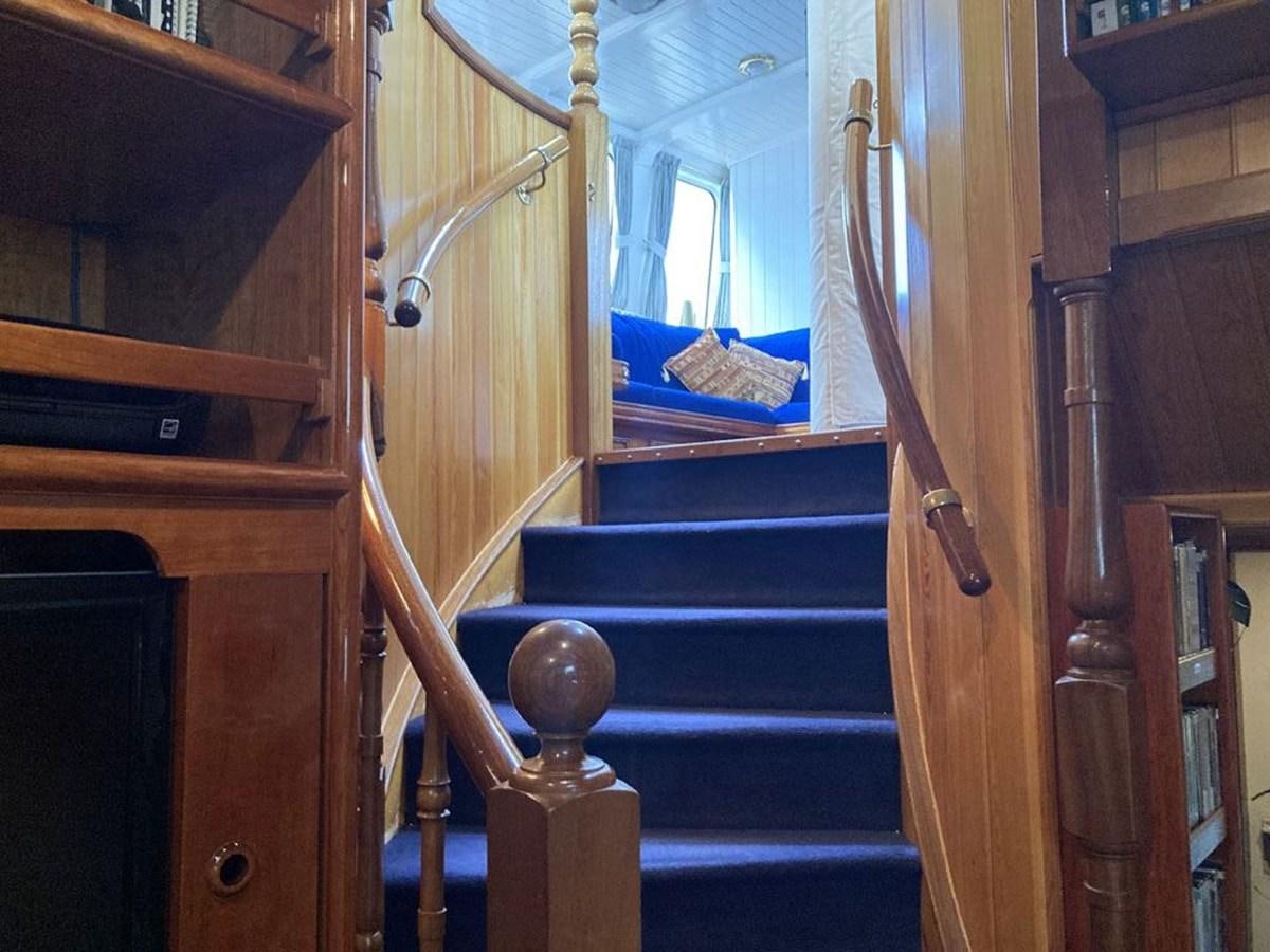 a room with wooden stairs and a blue staircase aboard TIGERLILY OF CORNWALL Yacht for Sale