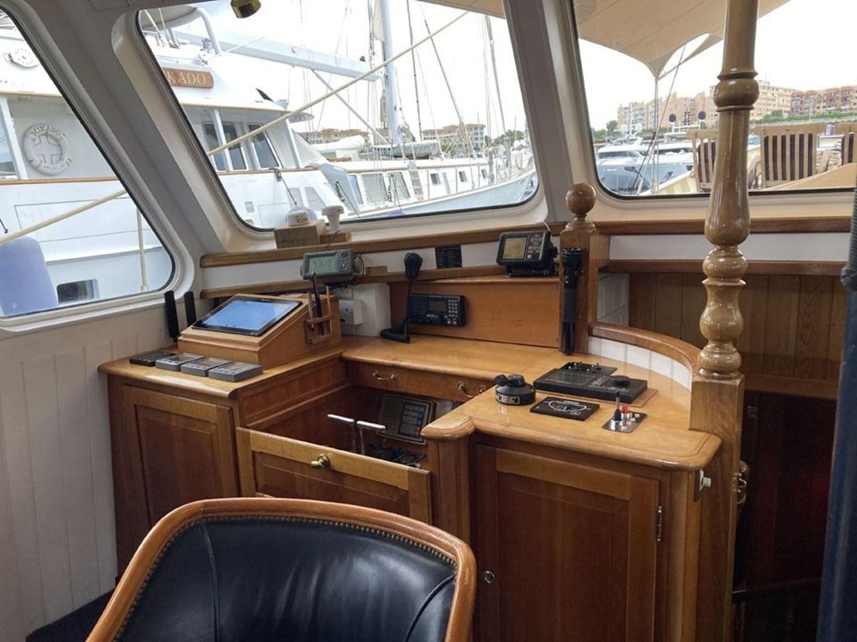 a room with a wood desk and a clock on the wall aboard TIGERLILY OF CORNWALL Yacht for Sale