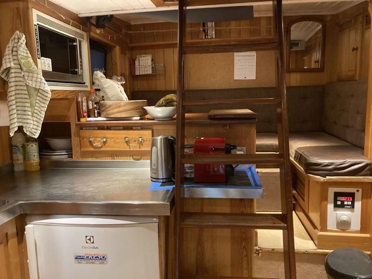 a kitchen with a wood cabinet aboard TIGERLILY OF CORNWALL Yacht for Sale
