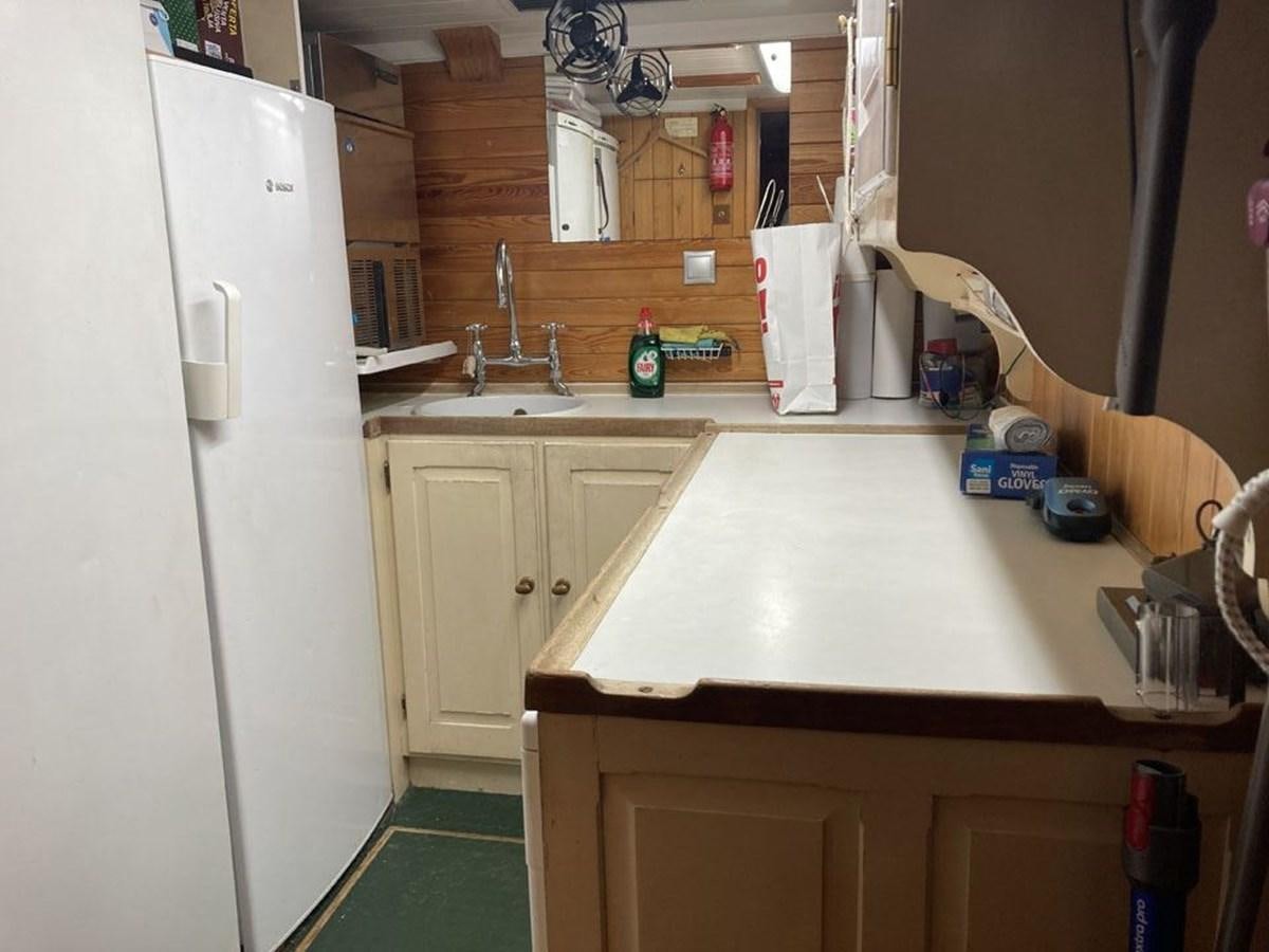 a kitchen with a sink and a refrigerator aboard TIGERLILY OF CORNWALL Yacht for Sale