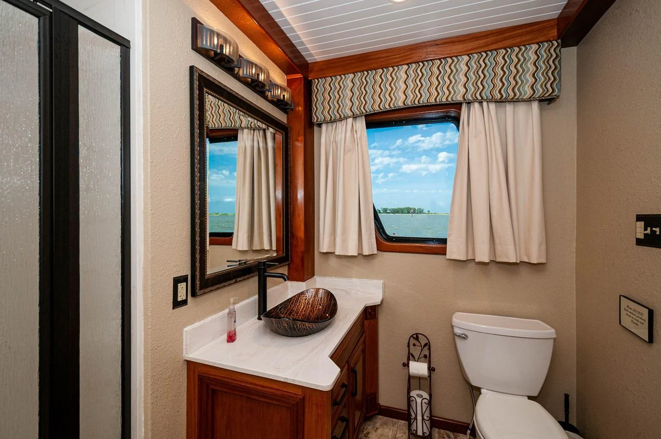 a bathroom with a toilet and a mirror aboard LE COLBY JEAN Yacht for Sale