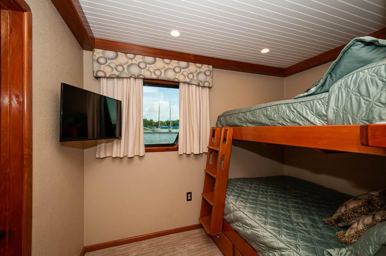 a bedroom with a tv on the wall aboard LE COLBY JEAN Yacht for Sale