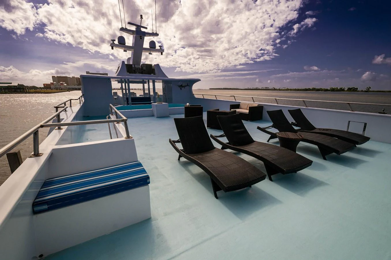 a pool with chairs and a couple of large white buildings in the background aboard LE COLBY JEAN Yacht for Sale