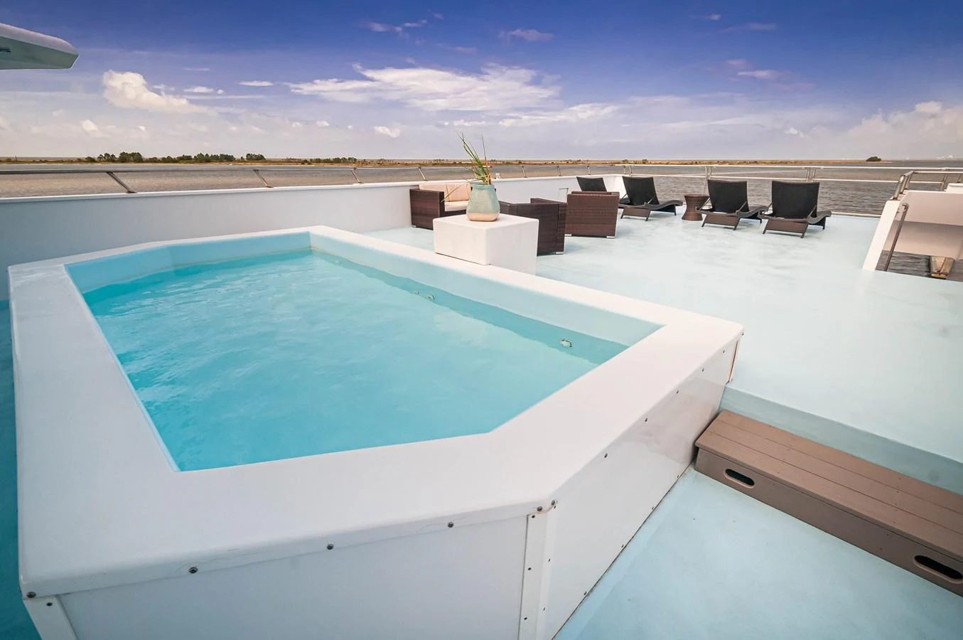 a pool with a table and chairs aboard LE COLBY JEAN Yacht for Sale