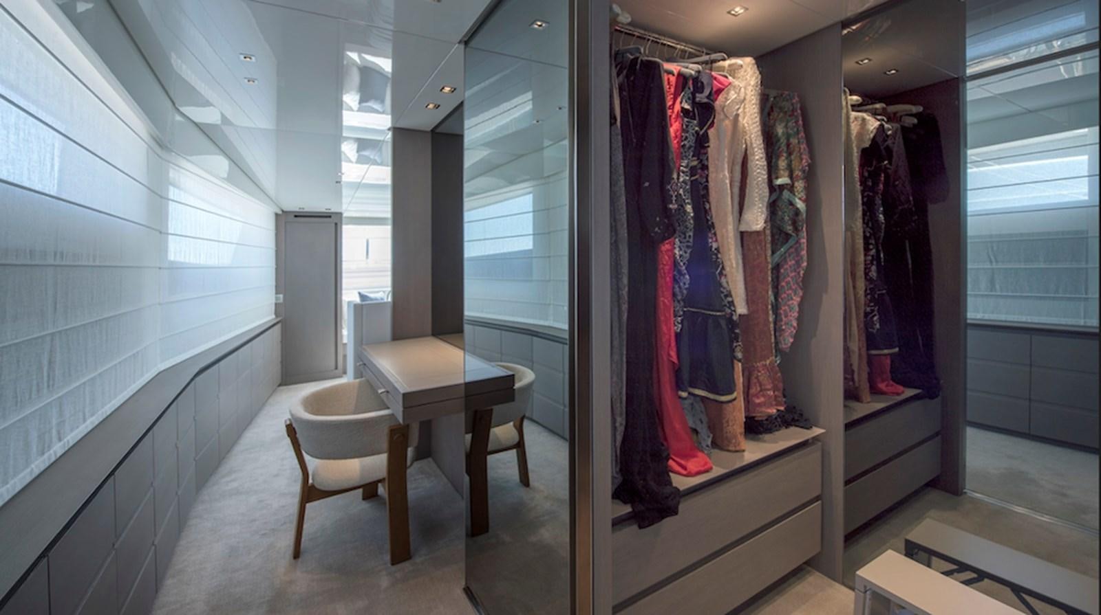 a room with a table and clothes on the wall aboard DINAIA Yacht for Sale