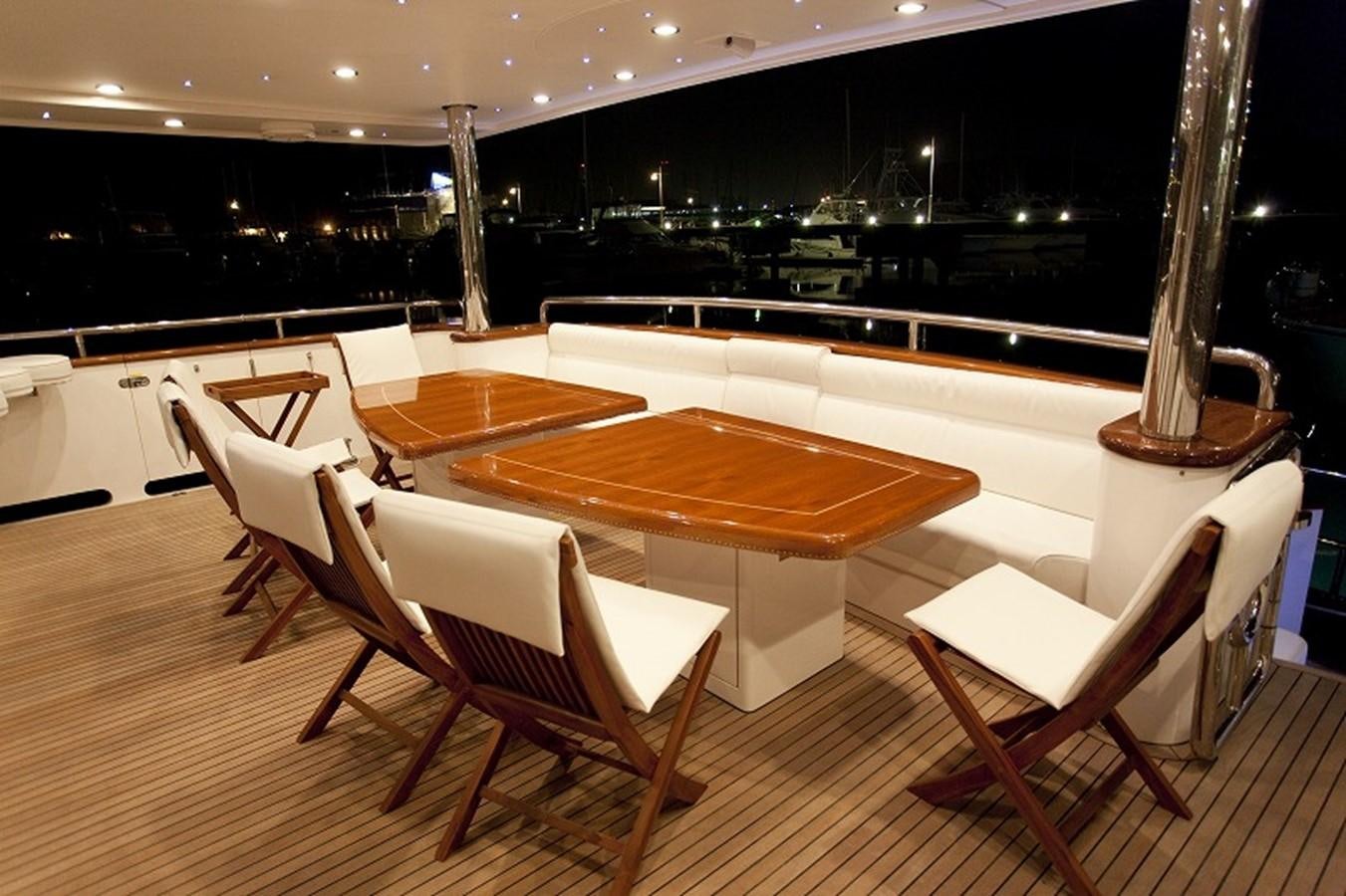 a room with tables and chairs aboard QUEEN GRACE Yacht for Sale