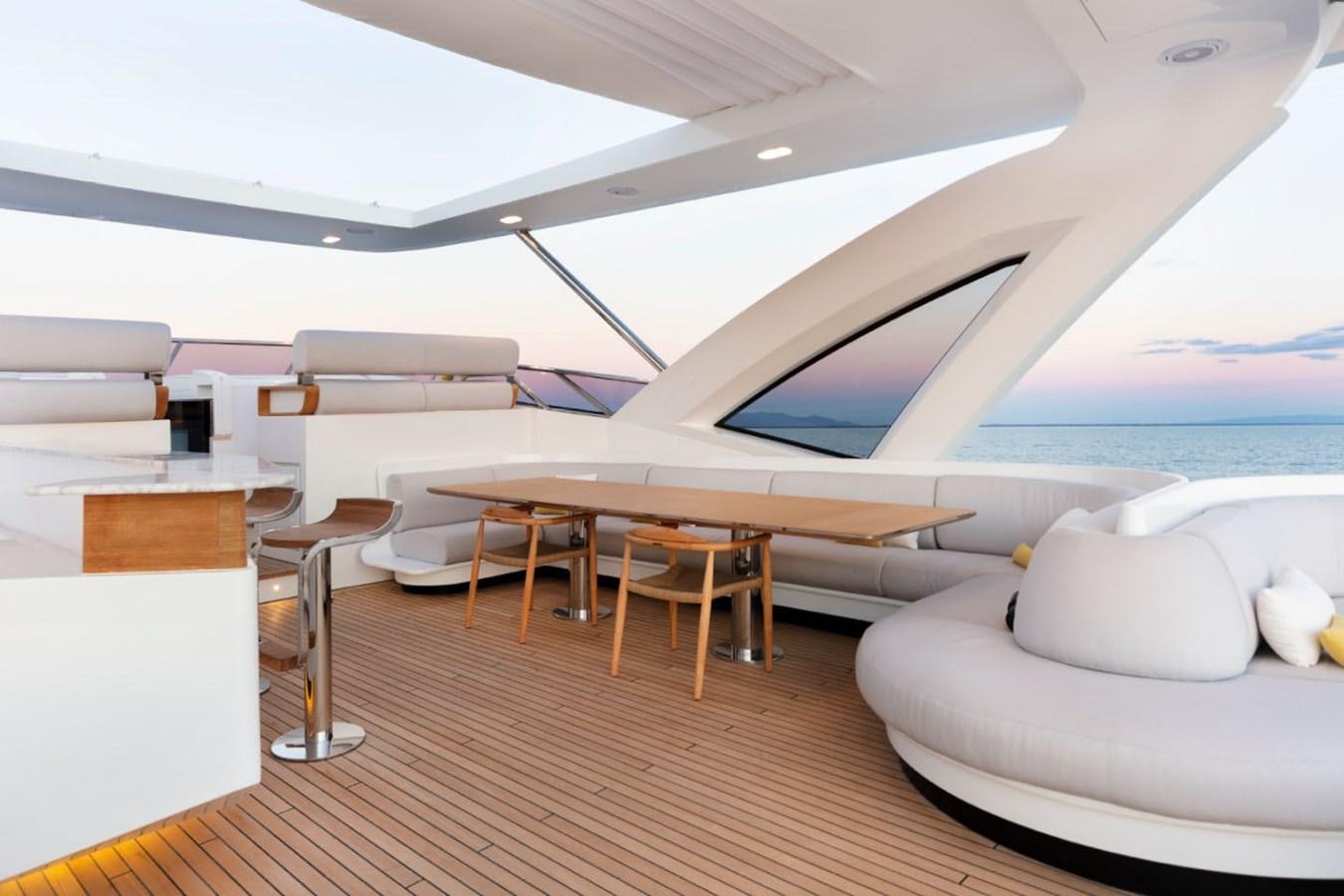 a room with a large bed and a table with chairs aboard ALBA Yacht for Sale