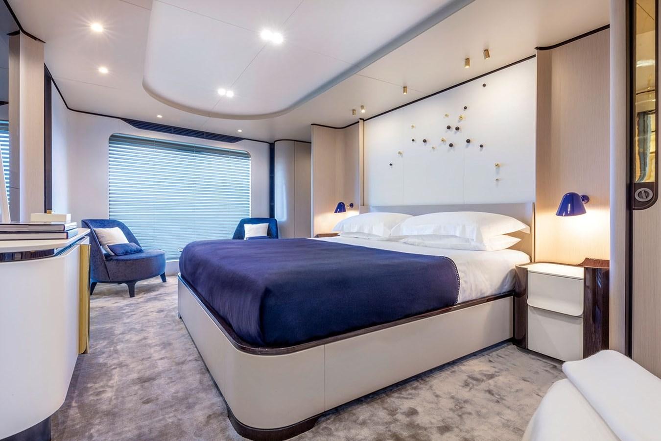 a bedroom with a bed and a chair aboard ALBA Yacht for Sale