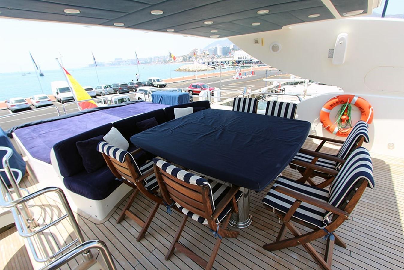 a deck with chairs and a table on it aboard MARIA JOSE Yacht for Sale