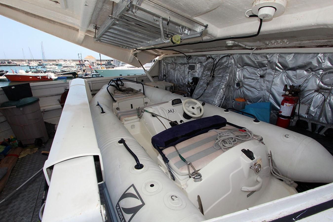 a large white boat with a blue cover and a black and white boat in the water aboard MARIA JOSE Yacht for Sale