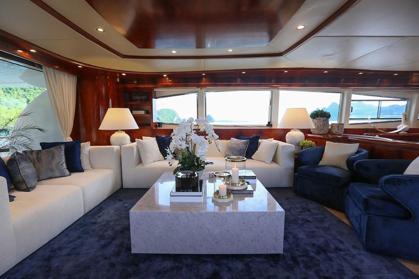 a living room with a large blue couch and a white coffee table aboard FOR YOUR EYES ONLY Yacht for Sale