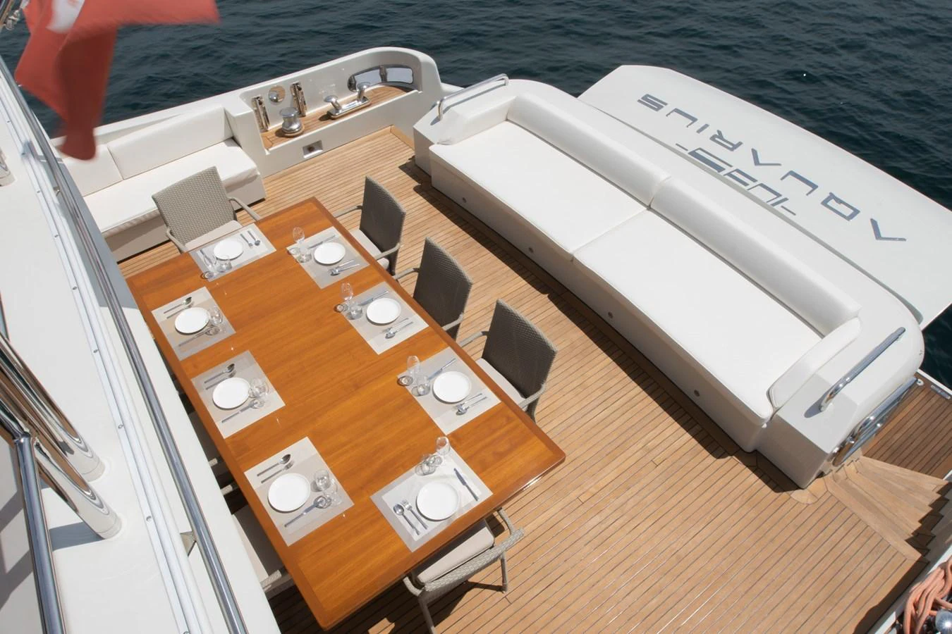 a wooden table with chairs and a piano on it aboard AQUARIUS Yacht for Sale