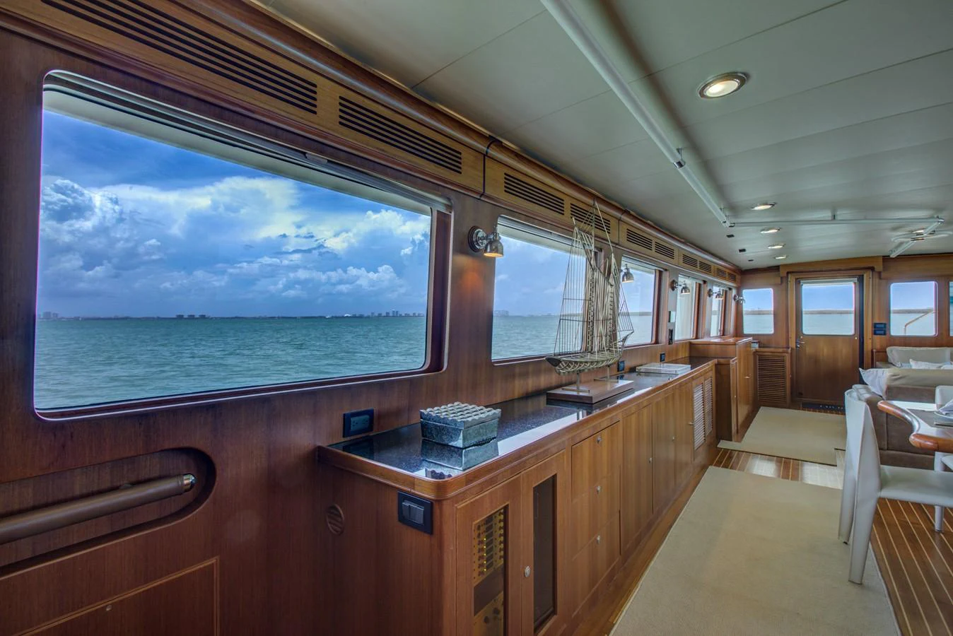 a room with a large window and a large blue ocean aboard EXPLORER 97E-CB Yacht for Sale