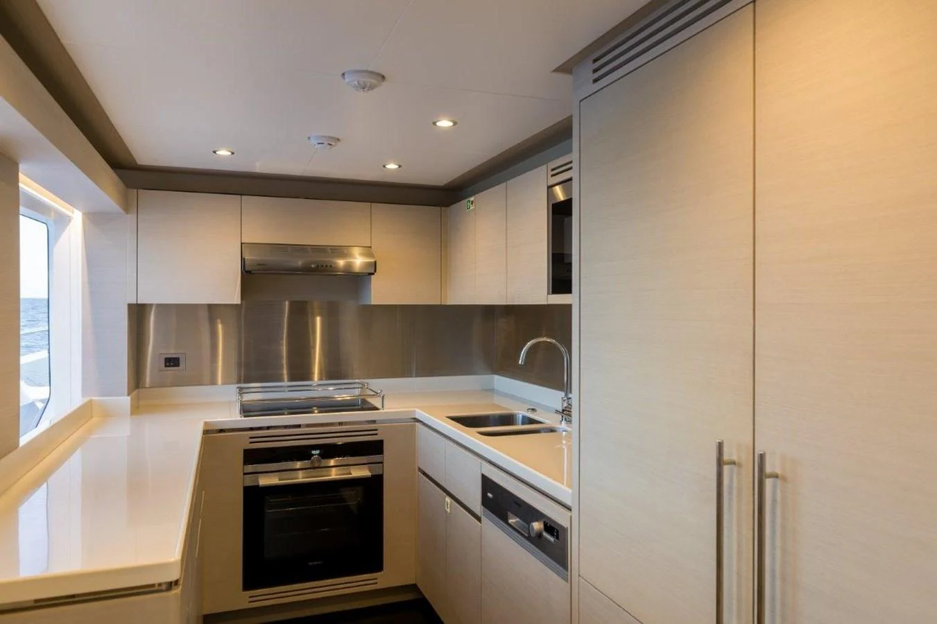 a kitchen with white cabinets aboard JEWEL Yacht for Sale