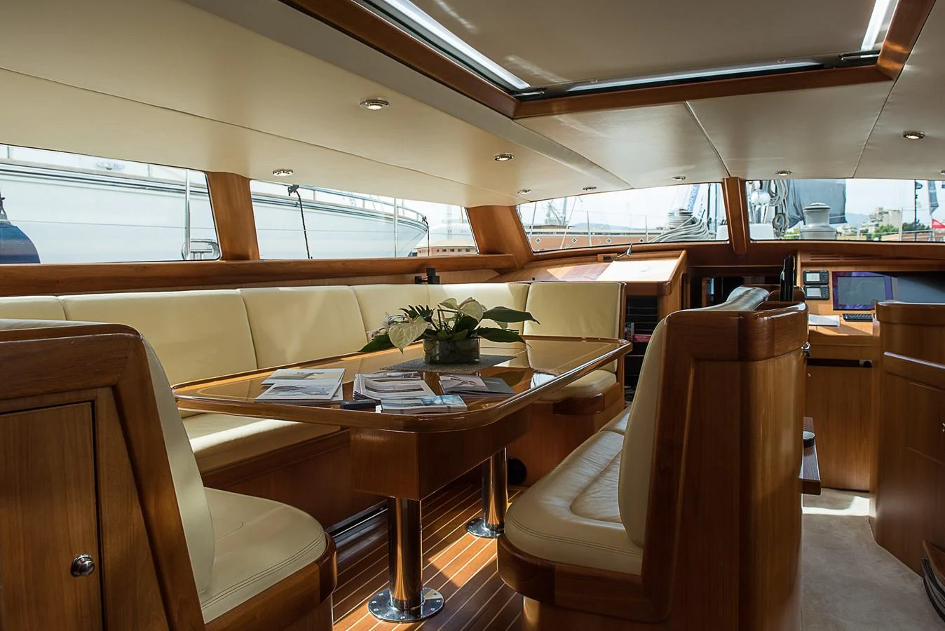 a room with a table chairs and plants aboard SINDONEMO Yacht for Sale