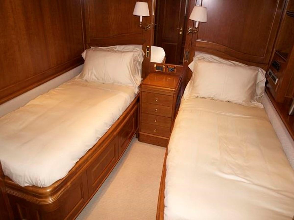 a room with a bed and a dresser aboard BENETTI TRADITION 100 Yacht for Sale